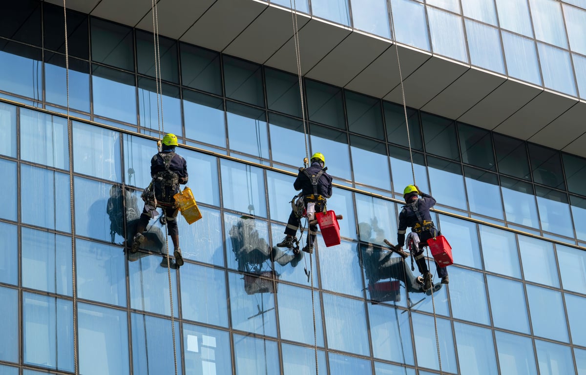 Workers cleaning the glass curtain wall of a high-rise building